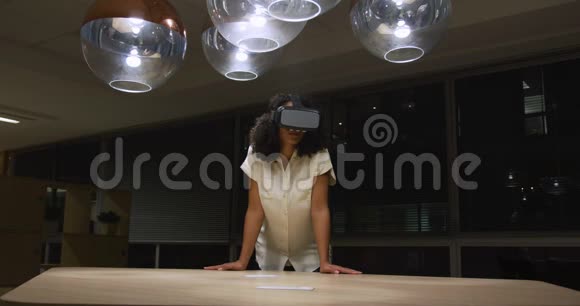 女商人在现代办公室里用VR头盔视频的预览图