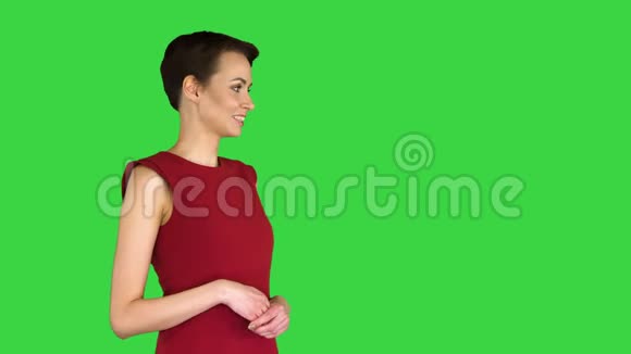 漂亮的女人穿着裙子说话和做手势就像在绿色屏幕上的天气预报Chroma键视频的预览图