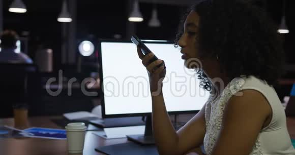 女商人晚上在现代化的办公室里工作和使用电话视频的预览图