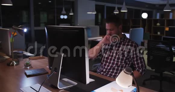 疲倦的商人晚上在现代化的办公室工作视频的预览图