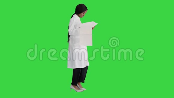 美国黑人医生妇女走路和看心电图记录在绿色屏幕Chroma键视频的预览图