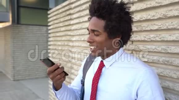 在办公楼附近使用智能手机的黑人商人视频的预览图