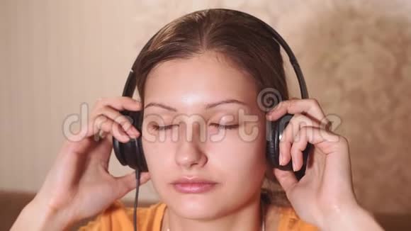 一个年轻女孩在家听音乐的肖像看着摄像机视频的预览图