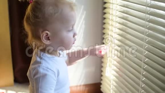 孩子推开百叶窗透过缝隙看着街道视频的预览图