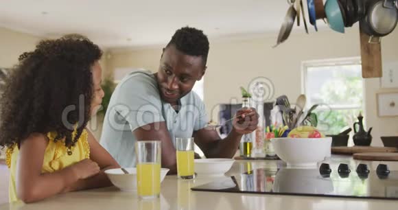 非裔美国人的父亲和女儿早上吃早餐视频的预览图