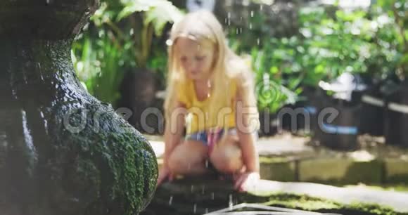 大自然中喷泉旁边的小女孩视频的预览图