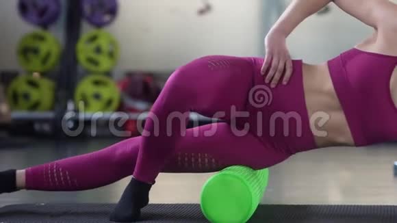 女人用绿色泡沫滚筒放松腿部肌肉视频的预览图