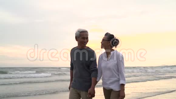 亚洲夫妇老年退休休息放松牵手散步日落海滩蜜月家庭在一起视频的预览图