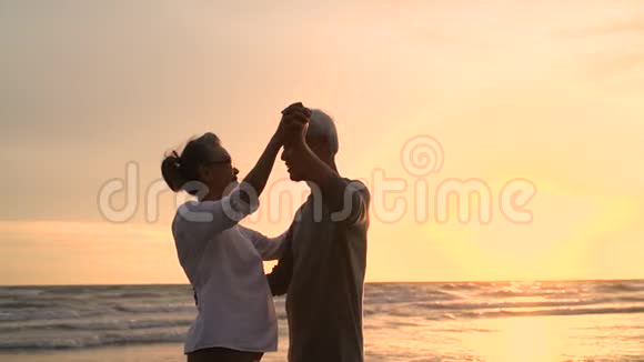 亚洲夫妇老年退休休息放松跳舞日落海滩蜜月家庭在一起视频的预览图