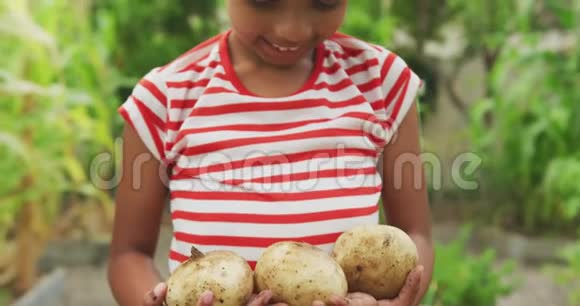 非裔美国女孩在镜头前展示土豆视频的预览图