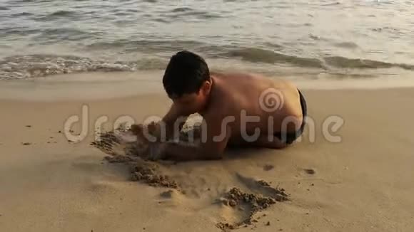 日落时分一个男孩在沙滩上玩视频的预览图