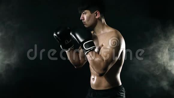 暗箱概念拳击手戴手套的人在黑色背景上与阴影搏斗个人体育娱乐活动慢慢视频的预览图