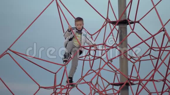 一个在红色攀爬网上的男孩视频的预览图