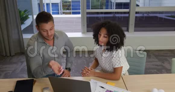 年轻的办公室主管在现代办公室讨论笔记本电脑视频的预览图