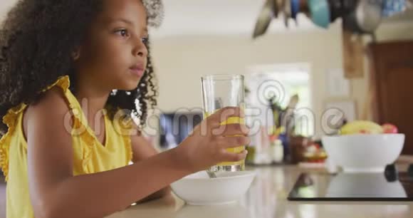 早晨喝果汁的非裔美国女孩的正面景色视频的预览图