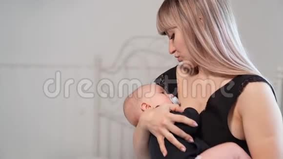 妈妈穿着黑色的摇篮宝宝嘴里放着奶嘴视频的预览图