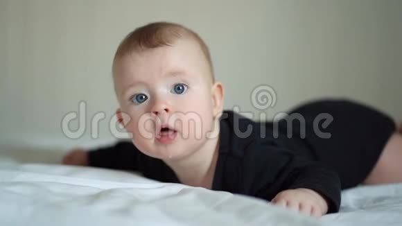穿着黑衣服的婴儿躺在白床板上视频的预览图