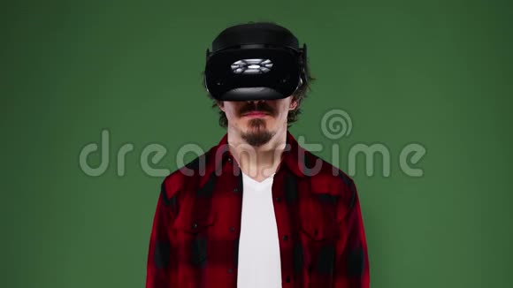 年轻人卷发使用VR耳机体验虚拟现实隔离在绿色背景铬钥匙视频的预览图