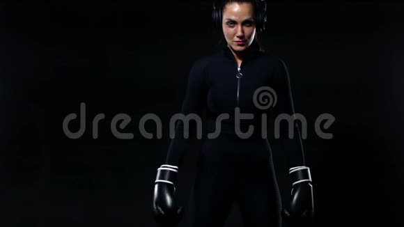 年轻女子运动员拳击手在健身房做拳击训练戴着手套穿着运动服的女孩视频的预览图