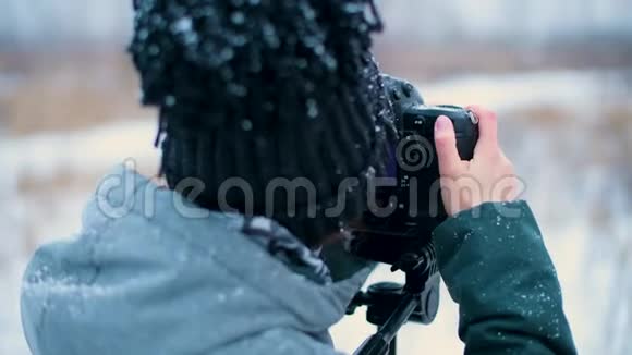 在冬天森林里拍照的女孩的特写镜头视频的预览图