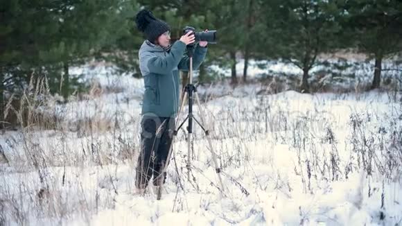 这个女孩在冬林里用照相机热情地拍照视频的预览图