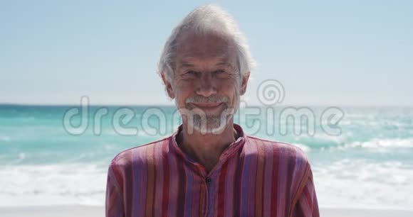 老人站在沙滩上看着镜头视频的预览图