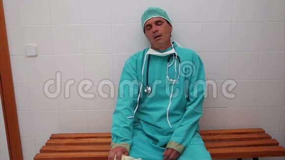 精疲力竭的外科医生坐在长凳上视频的预览图