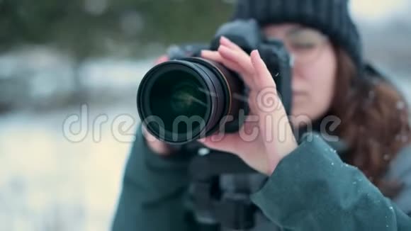 一位女摄影师在冬日拍摄一幅户外风景画视频的预览图