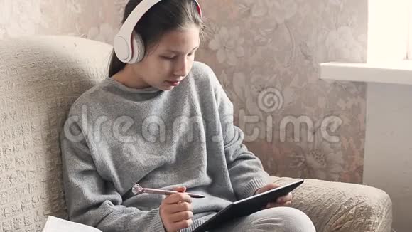 带着耳机课本和平板电脑的少女视频的预览图