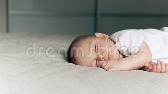 睡在灰色毯子上的可爱小男孩视频的预览图