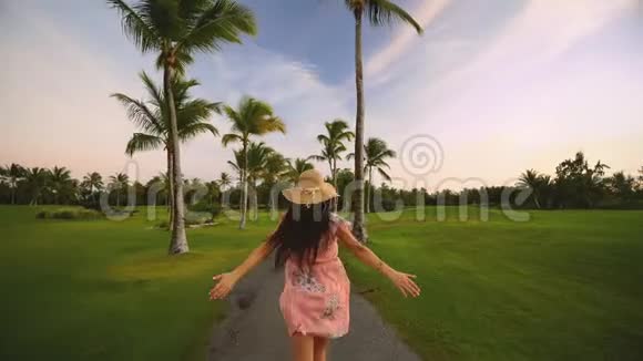跟随我的概念年轻的女人跑在热带高尔夫球场的道路上暑假或假期视频的预览图