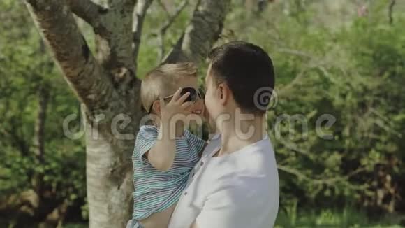 阳光明媚的一天小男孩和他的父亲在公园里玩耍和玩耍视频的预览图