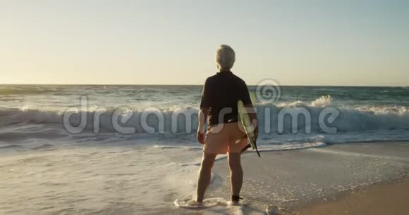 海滩冲浪板的后景老人视频的预览图