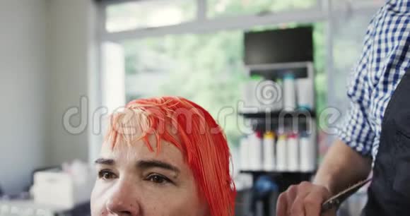 前景妇女的发型是理发师设计的视频的预览图