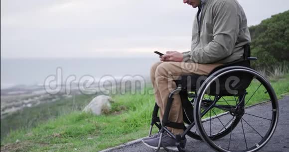 坐在轮椅上看手机的人视频的预览图