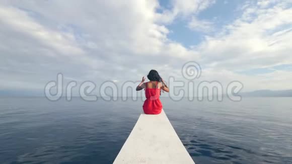 年轻而独立的女人在度假时享受在船上航行的自由视频的预览图