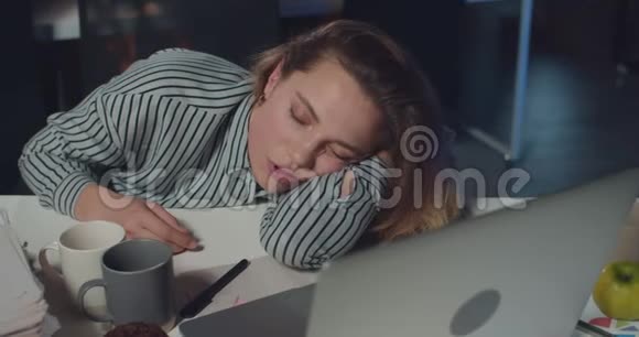 关闭疲惫的女上班族睡在打开的笔记本电脑前劳累过度的年轻女商人睡着了视频的预览图