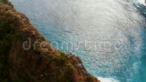 一个勇敢的人站在巴厘岛第三区的悬崖边上视频的预览图