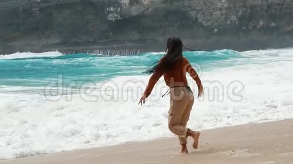 一个漂亮的女孩突然飞到巴厘岛的海浪中视频的预览图