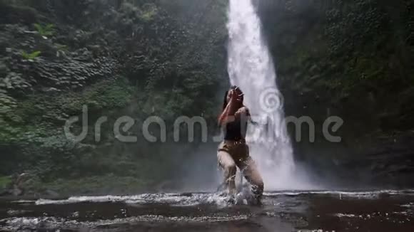 这个女孩在巴厘岛第二部分的一个华丽而又大的瀑布前翩翩起舞视频的预览图