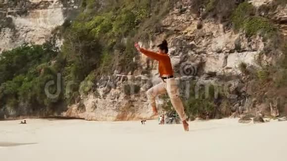 女孩做了一个凉爽的空翻沿着沙滩直奔巴厘岛的海洋视频的预览图