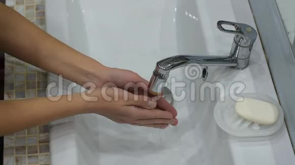 女孩洗手后双手合上了毛巾上的搅拌器视频的预览图