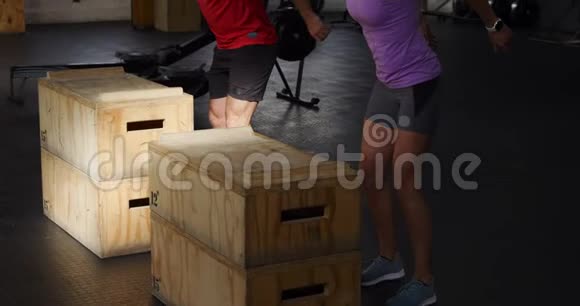 侧视运动白人男女跳上箱子视频的预览图