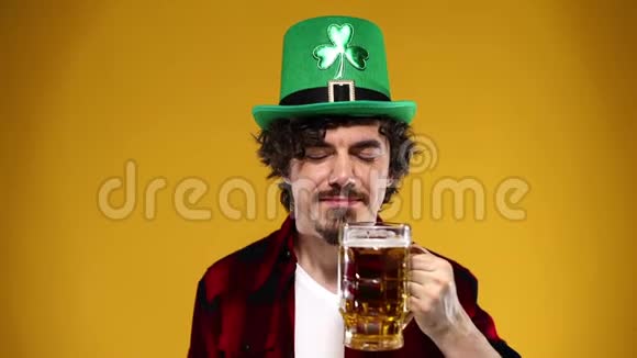 圣帕特里克节年轻的啤酒节男子提供大啤酒杯与饮料隔离在黄色背景动作缓慢视频的预览图