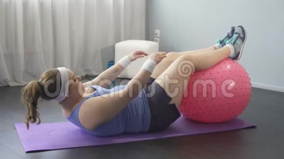 丰满的女孩努力减肥试图用手伸脚锻炼身体视频的预览图