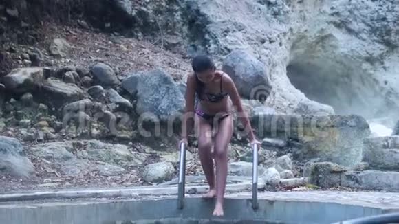 穿比基尼的苗条女人在天然温泉池里视频的预览图