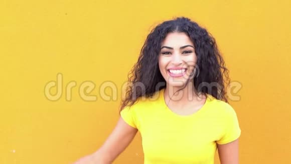 街上黄墙上的年轻阿拉伯休闲女子笑着笑着视频的预览图