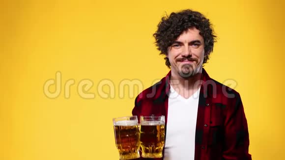 圣帕特里克节年轻的啤酒节男子提供大啤酒杯与饮料隔离在黄色背景视频的预览图