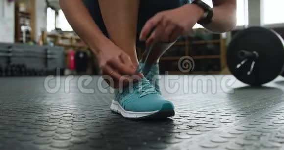 正面低视角一名运动白人妇女系鞋带视频的预览图