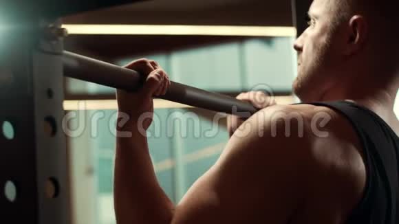 运动型英俊的男性运动员在健身房里用横杆工作强壮健康的健美腹部训练视频的预览图